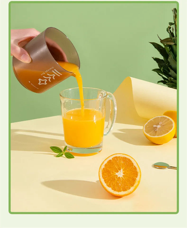 Green, pink and white manual plastic citrus juicer with 400ml capacity for portable use.