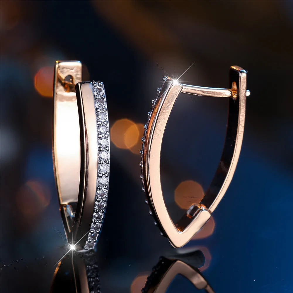 Geometric V-shaped women's ear clips in champagne gold with white diamond accents