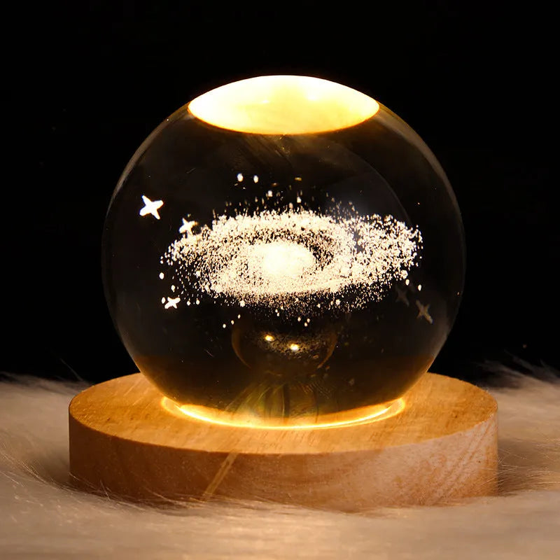 3D crystal ball night light projecting starry sky and planets from its 6cm sphere on a solid wood base.
