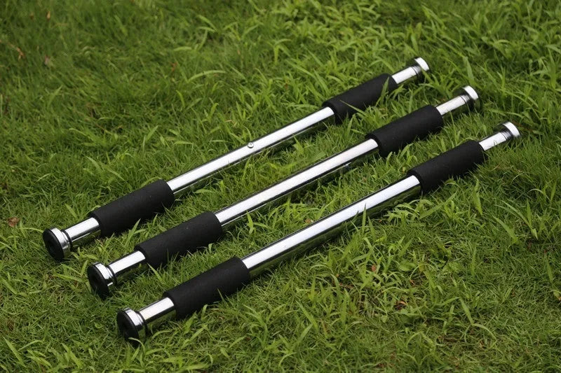 Steel adjustable pull-up bar extended across a door frame for home fitness training