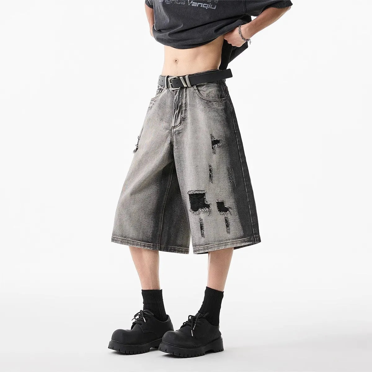 Grey denim shorts with washed finish and hole details, loose fit cropped length