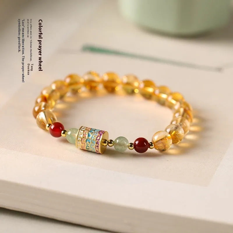 Yellow citrine prayer wheel bracelet with 8mm round beads on wrist