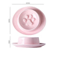 Green ceramic slow feeder pet bowl with maze pattern and non-slip silicone base on a kitchen floor.