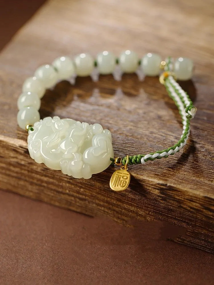 Modern red rope bracelet with a Hetian jade rabbit zodiac charm and a small silver card.