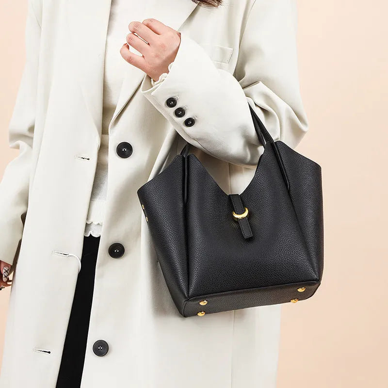 Genuine leather women's retro bucket handbag in beige with sewn detailing and an outer pocket.