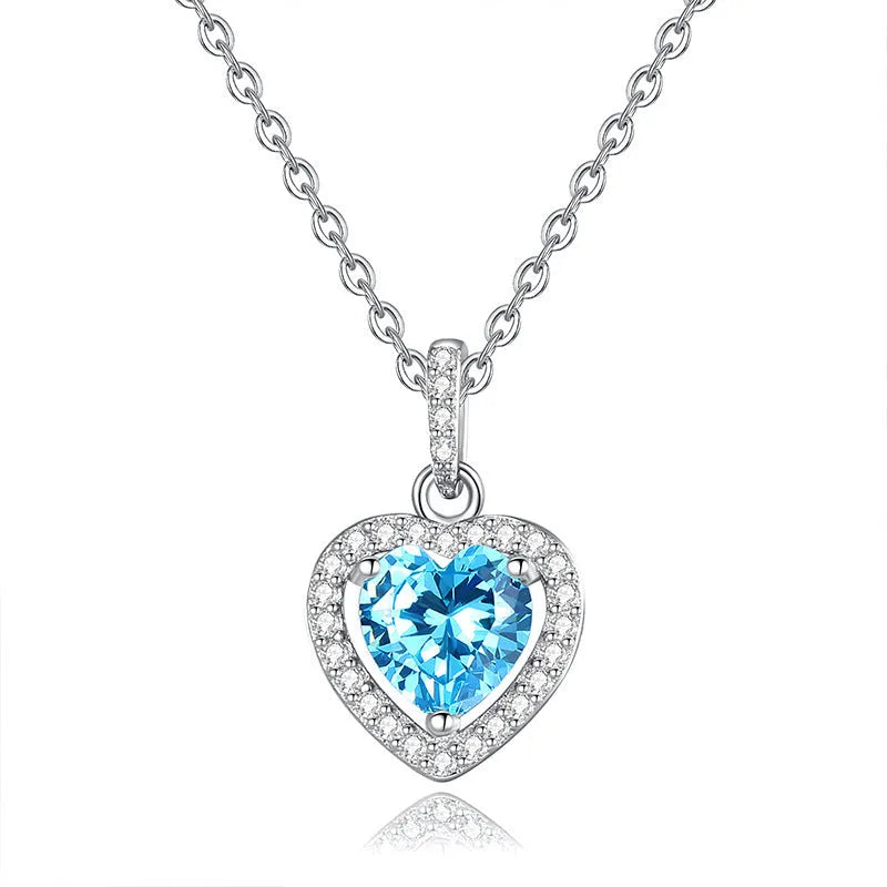 Heart-shaped sterling silver necklace with a coloured gemstone on an adjustable cross chain.