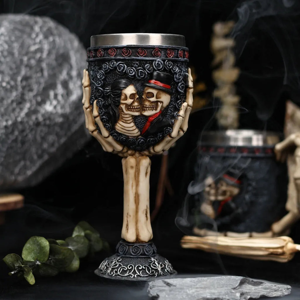 Two stainless steel red wine glasses with a detailed skeleton design, shown as a couple's set.