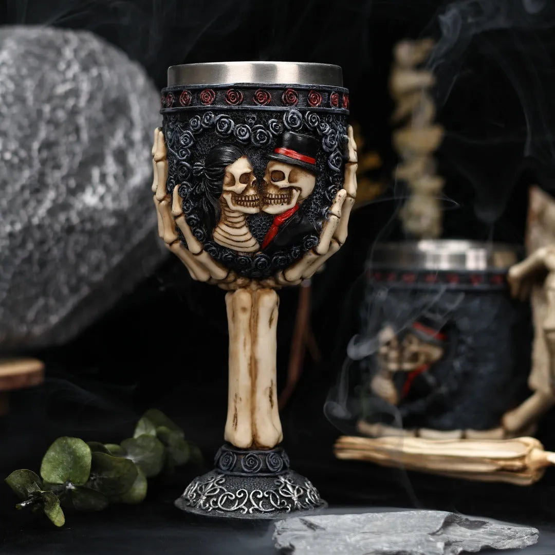 Two stainless steel red wine glasses with a detailed skeleton design, shown as a couple's set.