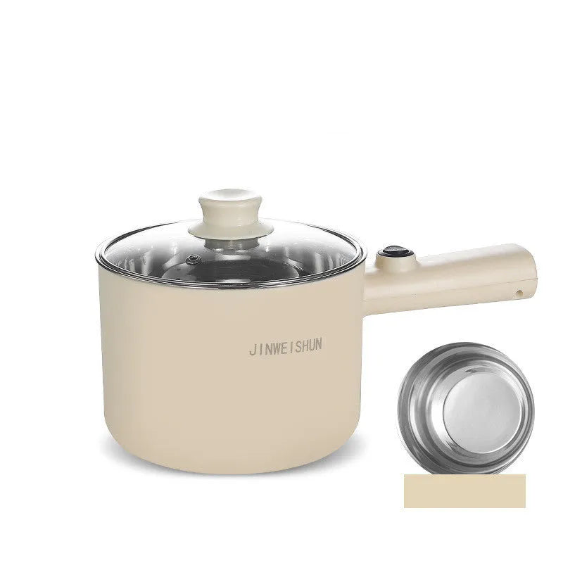 White and green mini electric hot pot cooker with stainless steel body and cooking accessories on a kitchen counter.