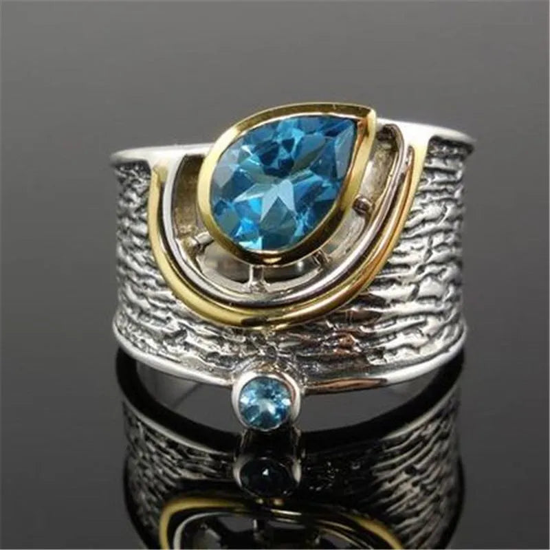 Drop-shaped blue zircon ring with inlaid stones on alloy band, showing sizes 6-10 for women's jewellery.