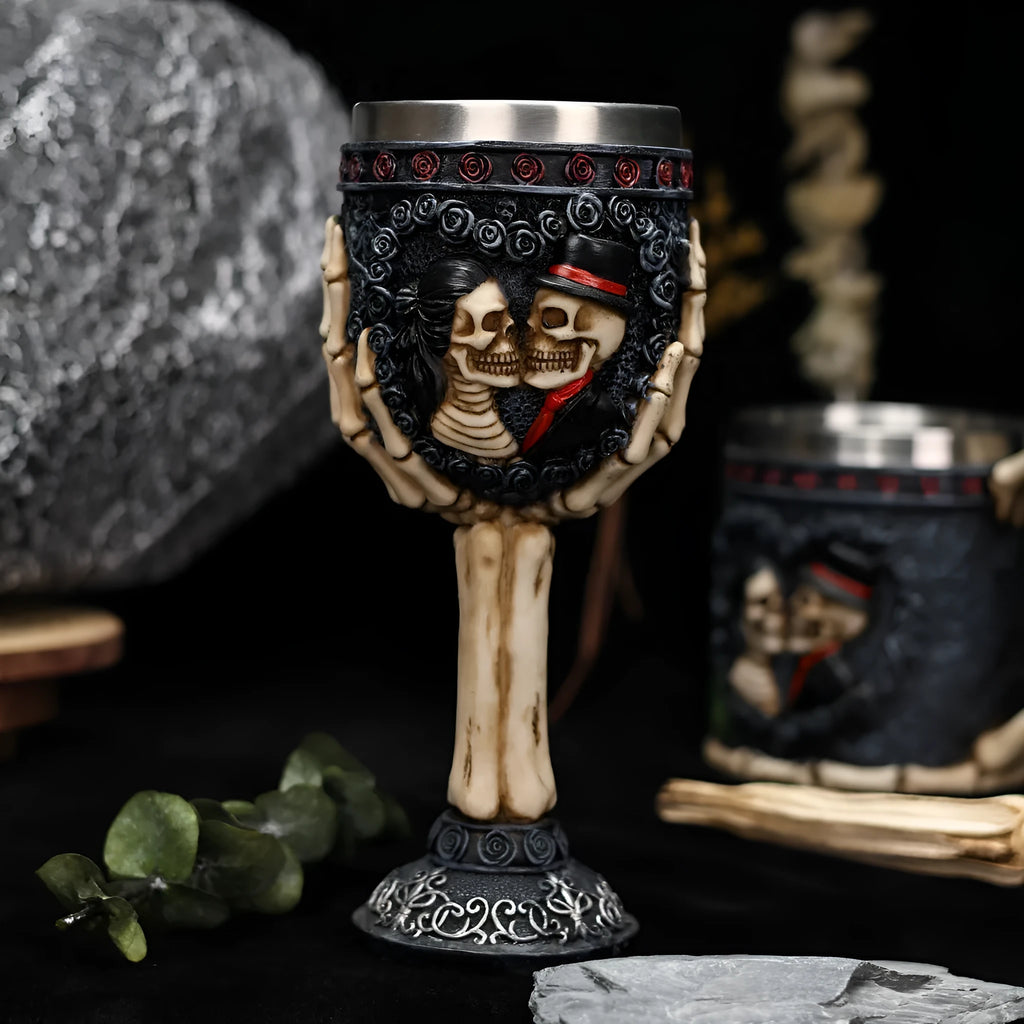 Two stainless steel red wine glasses with a detailed skeleton design, shown as a couple's set.