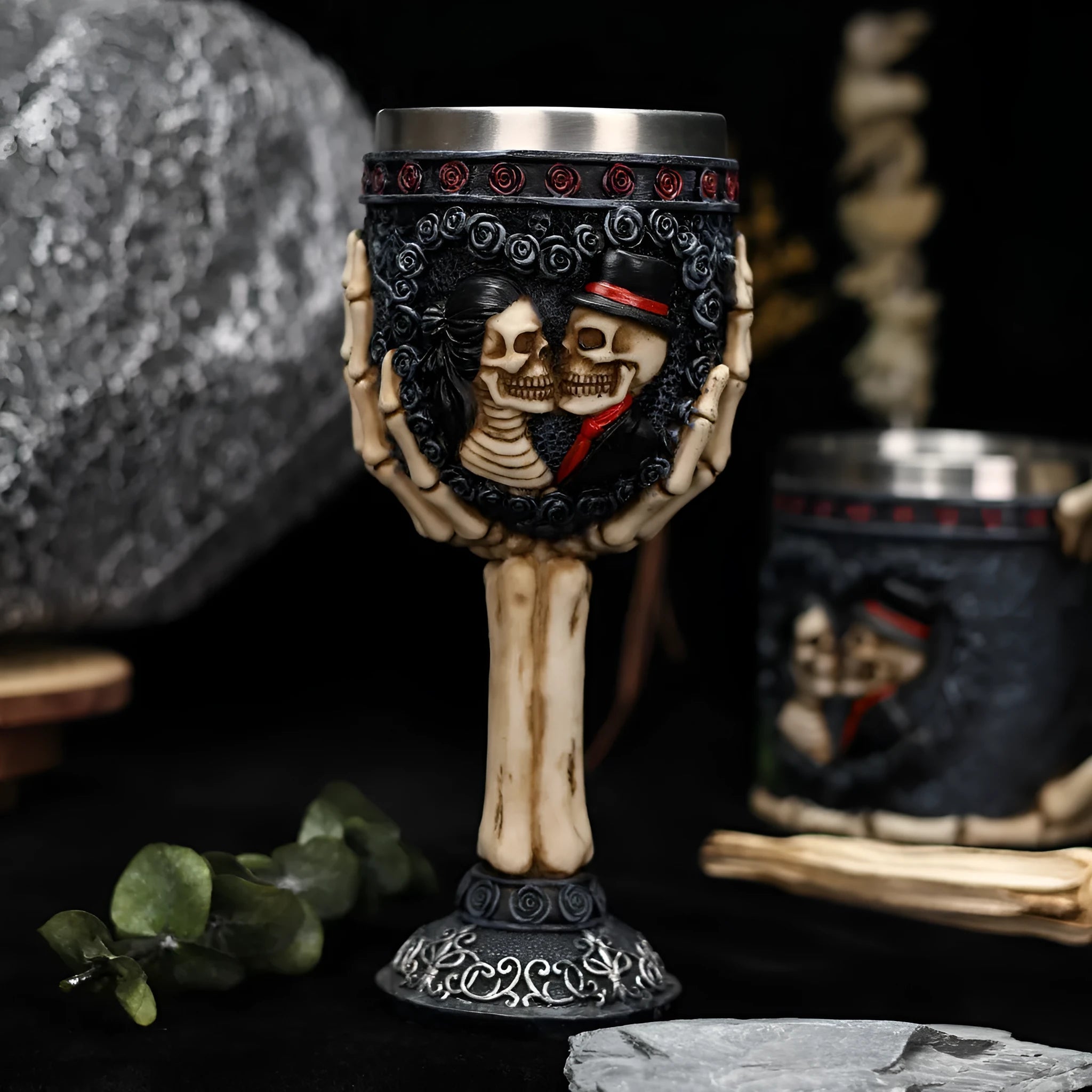 Two stainless steel red wine glasses with a detailed skeleton design, shown as a couple's set.