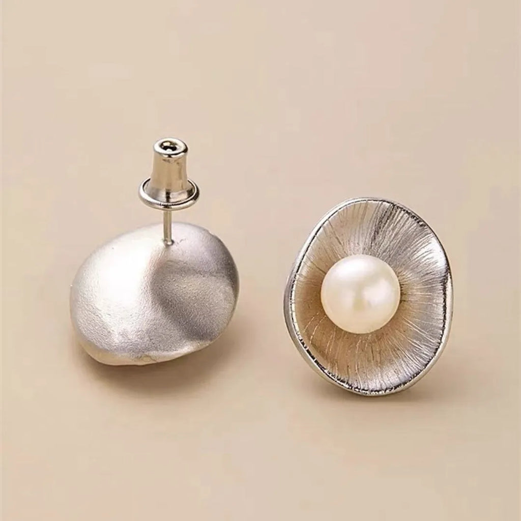 Pearl sterling silver needle earrings with geometric design and 8mm freshwater pearl centrepiece on gold background
