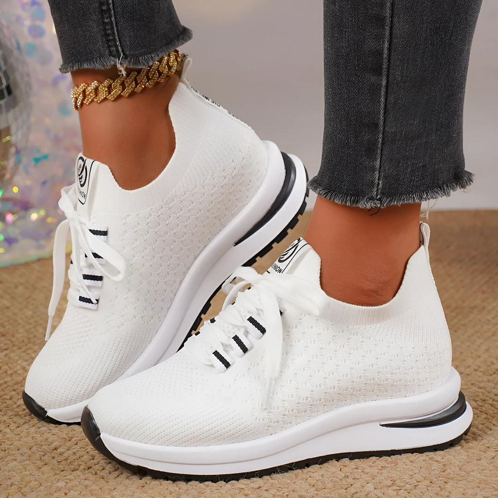 Women's black and white flat lace-up mesh sneakers on a white background
