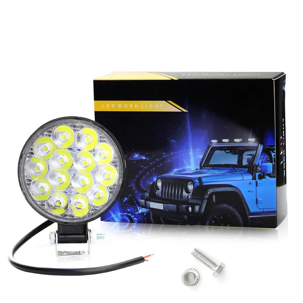 White mini round aluminium LED work light with IP67 rating for vehicle use.