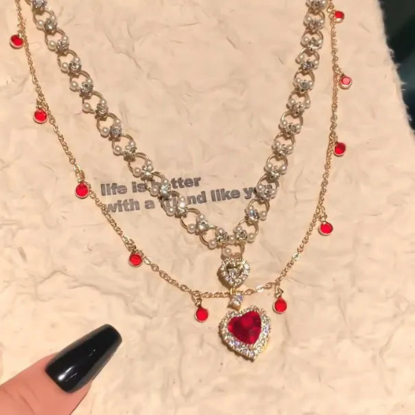 Red double layer necklace with two chains, a heart pendant, and an adjustable clasp.