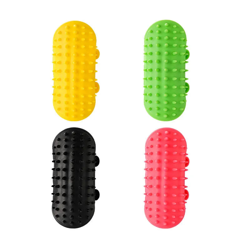 Black silicone cat grooming comb with adjustable strap attached to a table leg, showing rounded teeth for hair removal