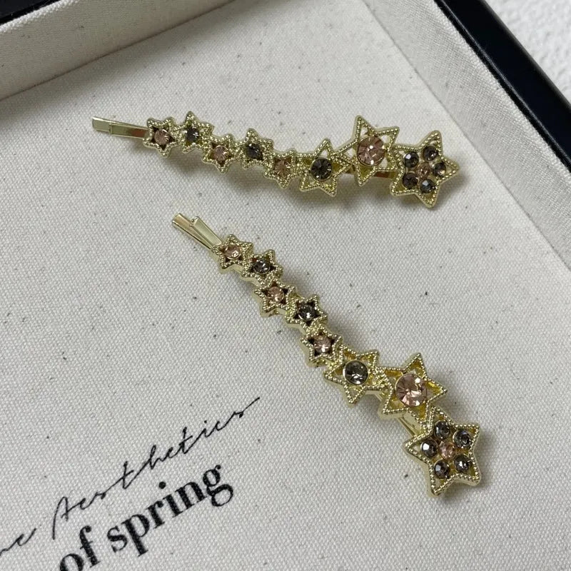 Gold metal hair barrette with a star charm and side clip for bangs.