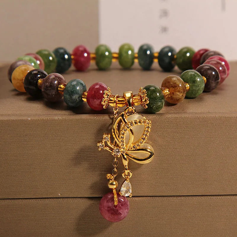 Colourful women's alloy bracelet with multicoloured beads and a butterfly charm on a wrist.