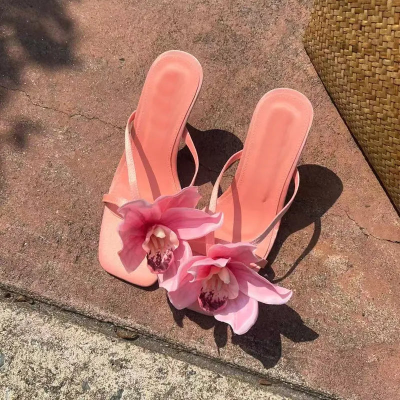 Pink women's high heel sandals with artificial white phalaenopsis flowers on the satin upper