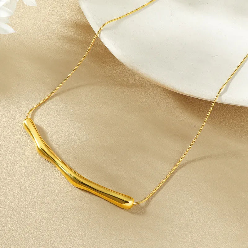 Close-up of a women's titanium steel necklace with an irregular pleated texture, shown in a gold tone finish.