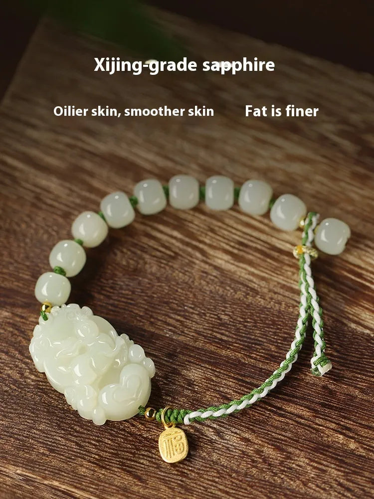 Modern red rope bracelet with a Hetian jade rabbit zodiac charm and a small silver card.
