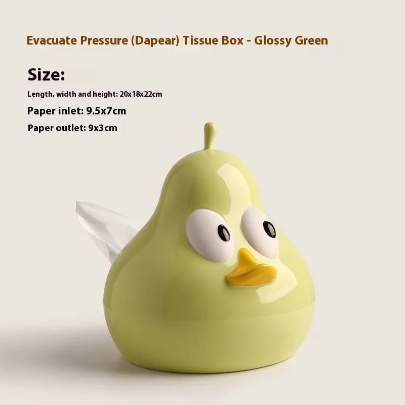 Green ceramic pear tissue box with animal style design on a wooden desktop