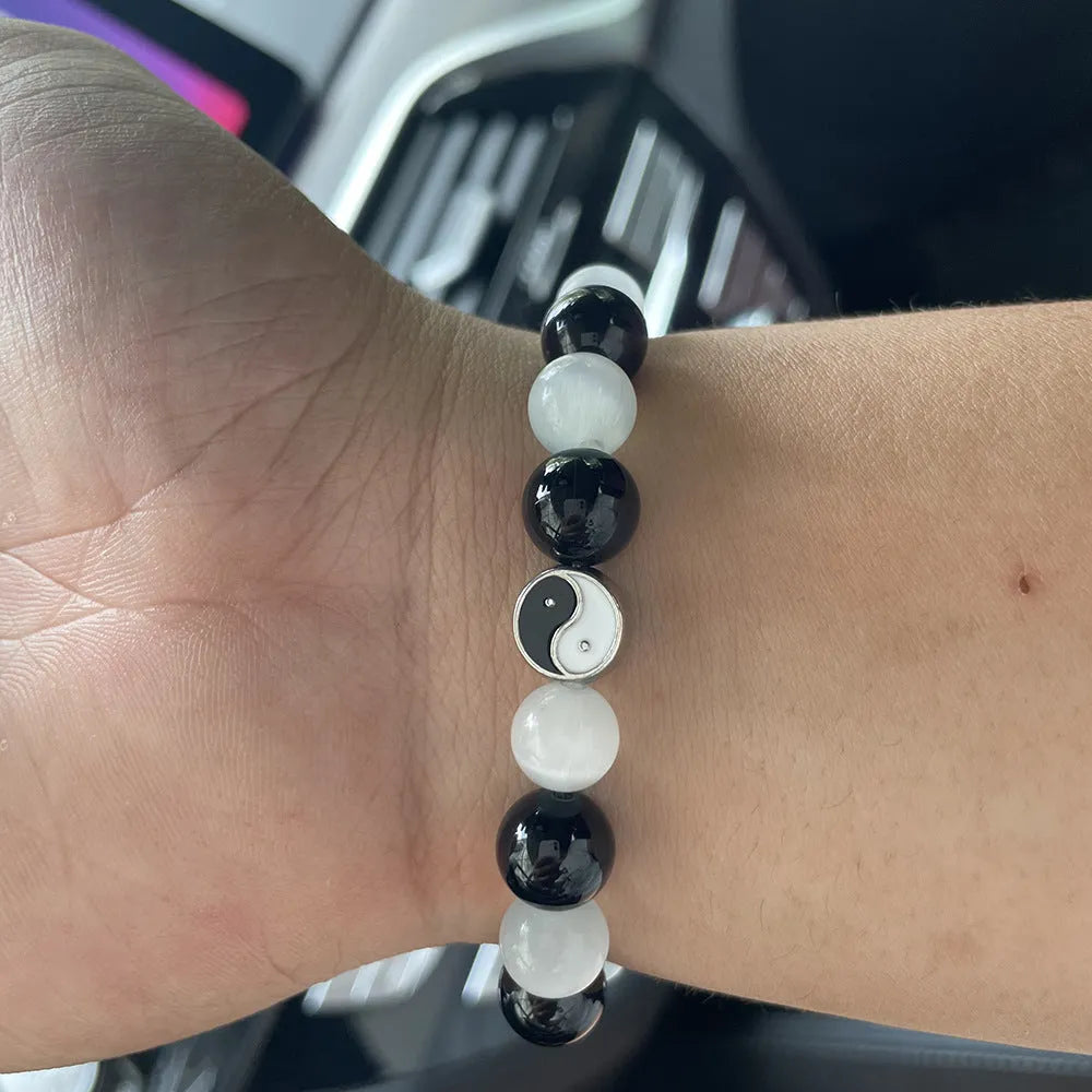 Close-up of a 10mm natural opal and black agate beaded bracelet in a Tai Chi style.