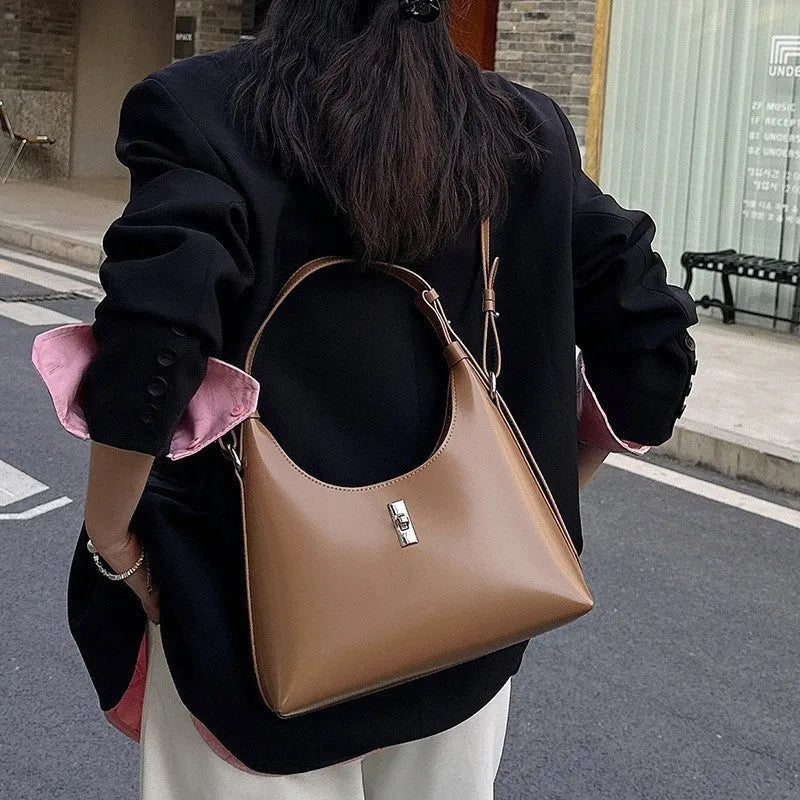Genuine leather crossbody shoulder bag with dumpling shape, internal organisation pockets, and street trend style details