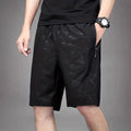 Men's loose sports shorts in black, grey, or blue with printed design, elastic waistband, and fifth pants length.