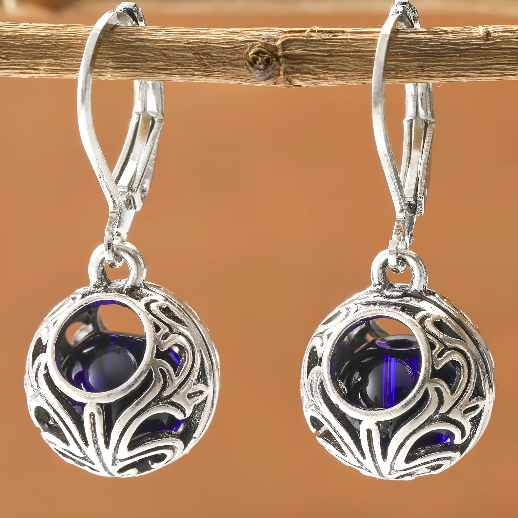 Silver geometric pendant earrings with vintage engraving and hollow design around blue gemstone
