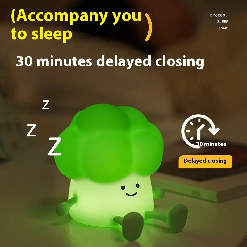 Cartoon-shaped eggplant night lamp glowing with soft yellow light on a table.