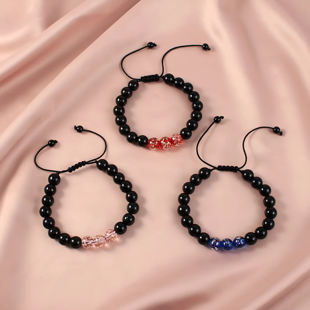 Geometric adjustable bracelet with luminous glass beads in sapphire blue on a wrist.