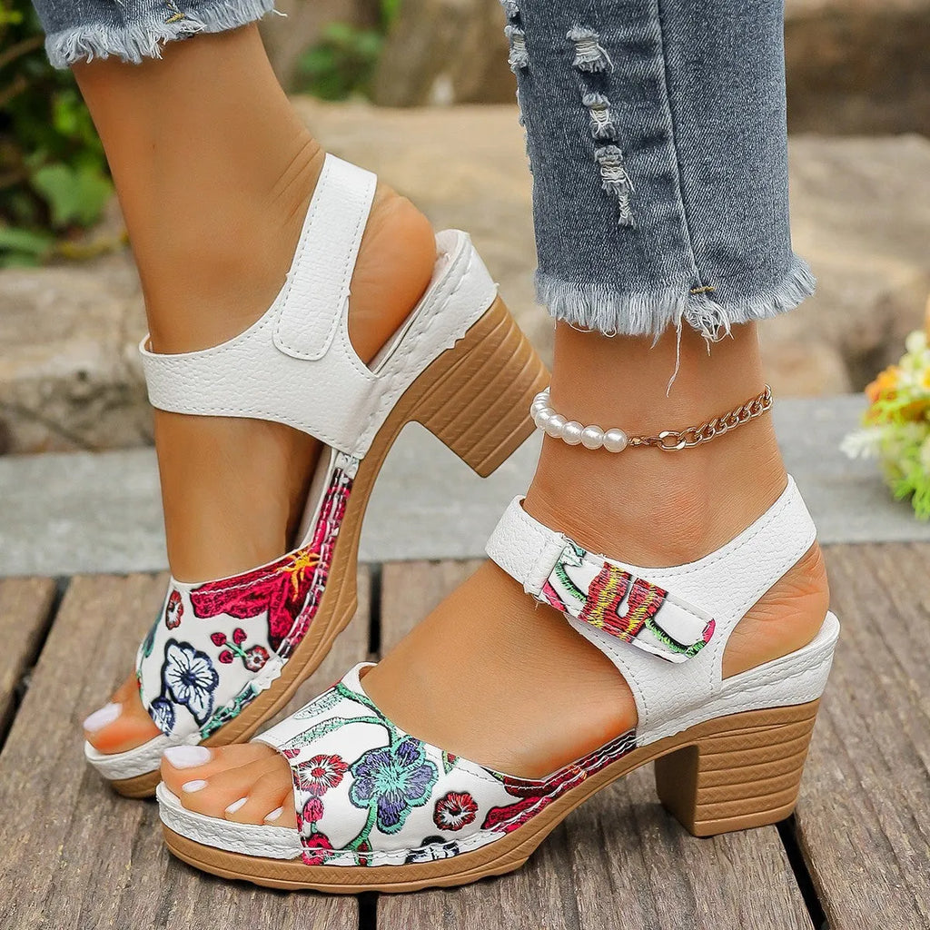 White women's high heel sandals showing velcro buckle fastening and rubber sole