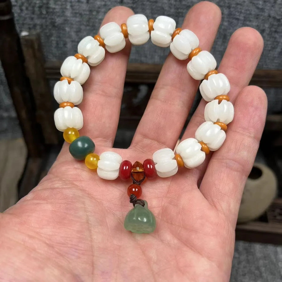 Hand-carved Bodhi root bracelet with White Jade beads, lotus carvings, and a cat's paw pendant.