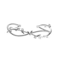 Close-up of an adjustable white gold coloured copper bracelet with a twisted branch and sprout design.