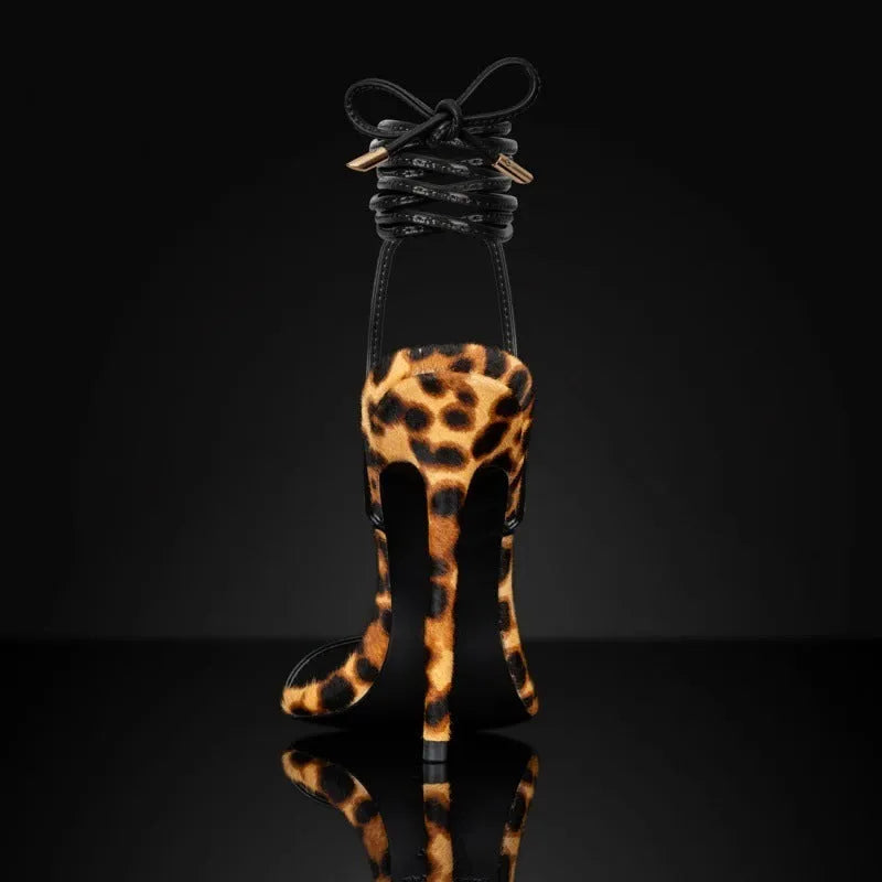 Women's leopard print sandals with a pointed toe and Roman lace-up buckle on a flat rubber sole.