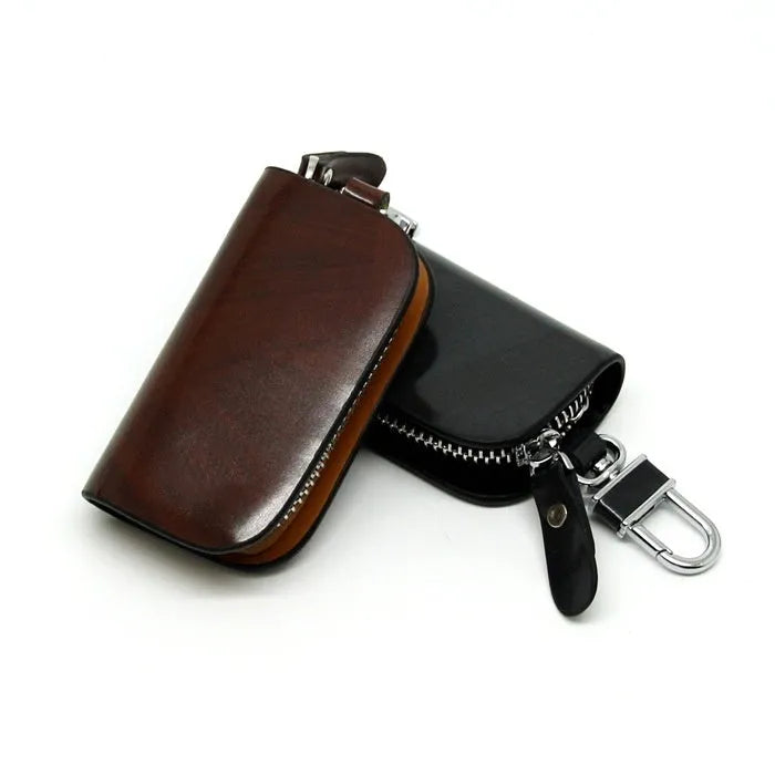 Black or brown genuine leather car key case with zipper, showing soft cowhide texture and internal size of 9.5cm by 4.5cm
