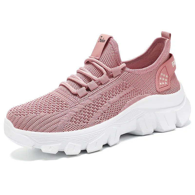 Women's Flyknit sneakers in beige with flat heel, round toe, and lace-up front, showing breathable upper and PVC sole