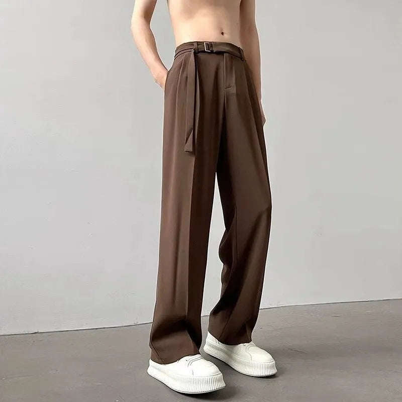 A woman wearing thin black wide-leg straight trousers with a loose, casual fit.