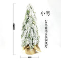 24-inch desktop Christmas tree with PE snow simulation and integrated lighting on wooden surface