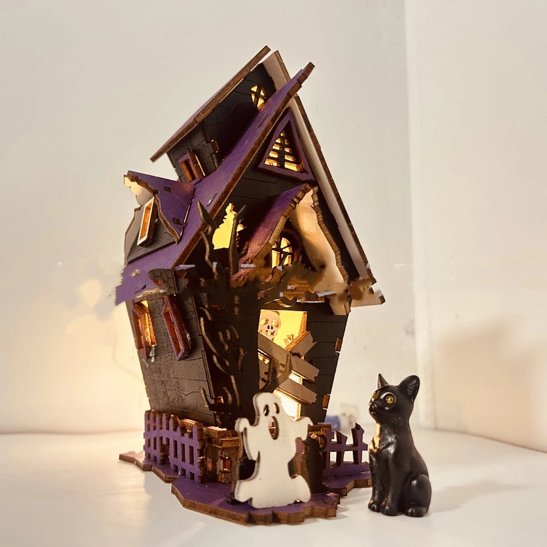 Wooden haunted house Halloween decoration measuring 14x10.5x19cm with luminous finish and cut-out details