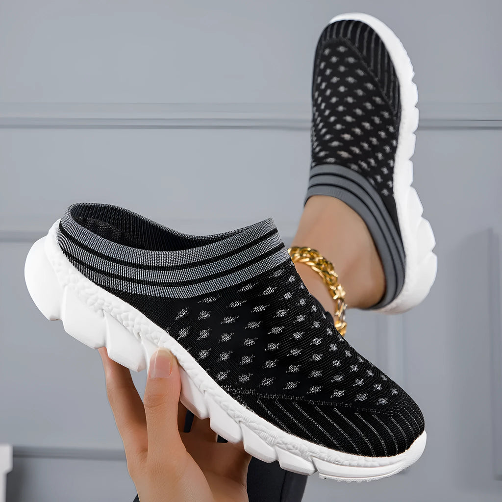 Women's black Flyknit slipper shoes with striped pattern and hollowed-out design on a white background.