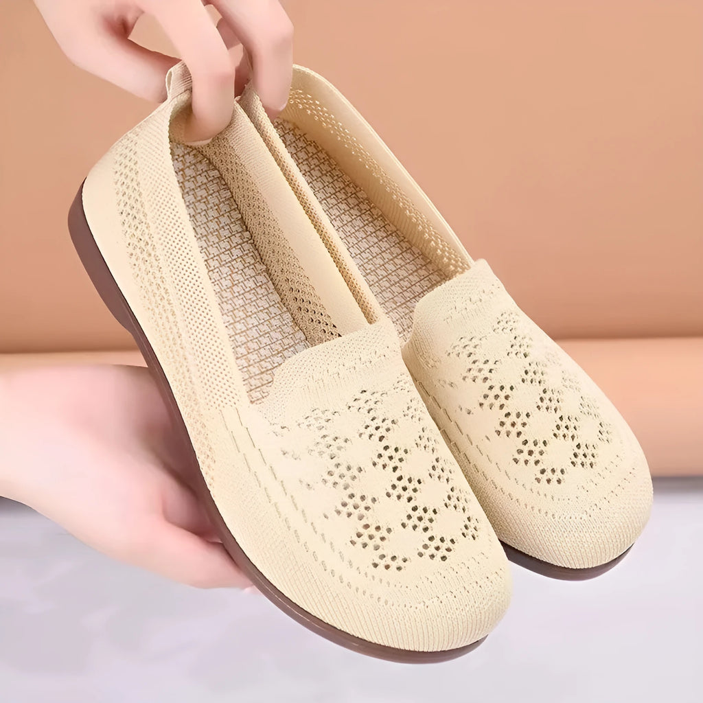 Beige low-top mesh tennis shoes for women with wide feet, showing breathable upper and flat PVC sole.
