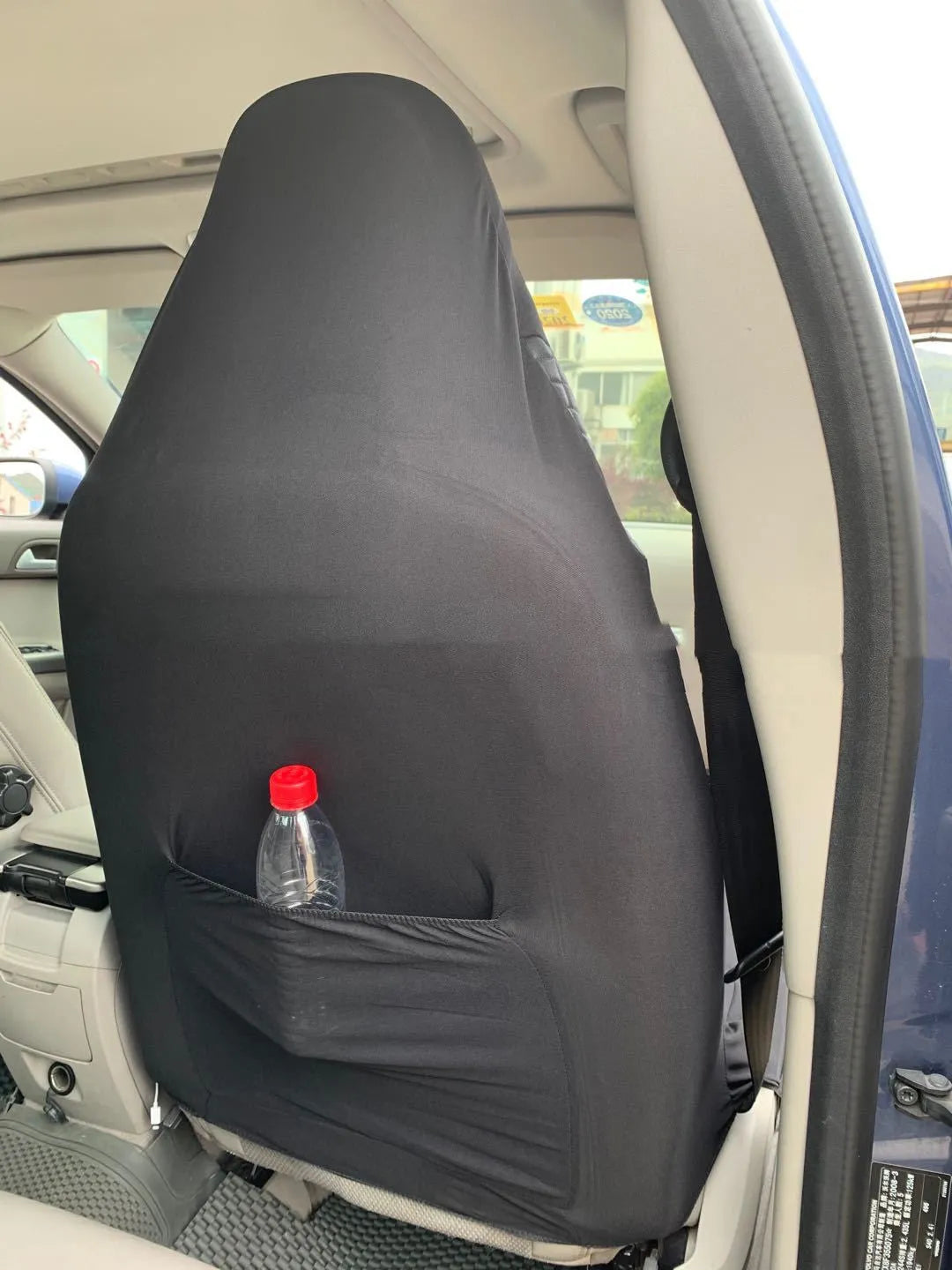 Black quilted automotive seat cover with PU and polyester fabric, showing sponge layer and plastic hooks