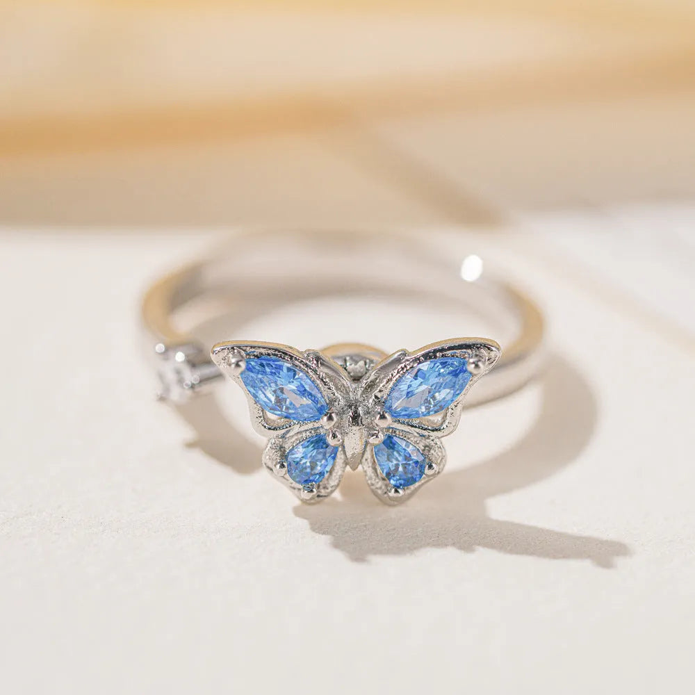 Adjustable butterfly ring in electroplated copper, available in white gold or yellow gold with blue or pink diamond finish