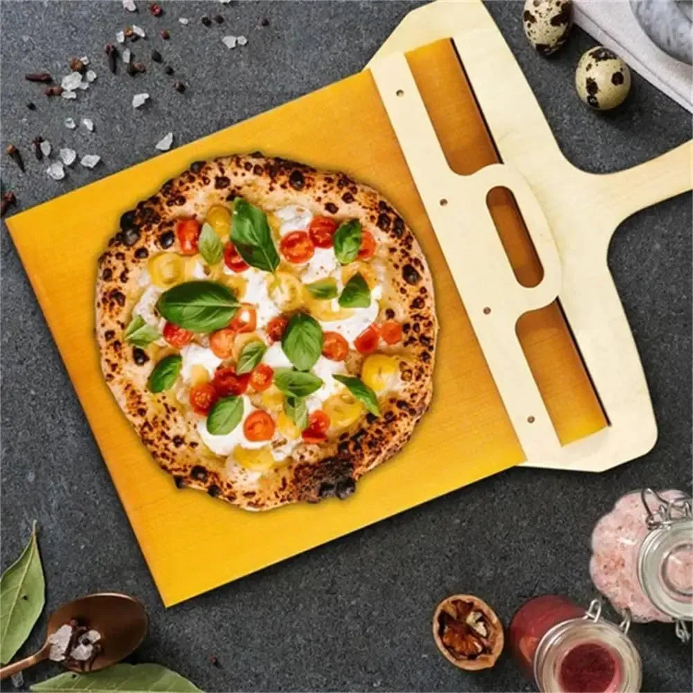 White plastic pizza transfer shovel with handle and hanging hole on a kitchen counter.