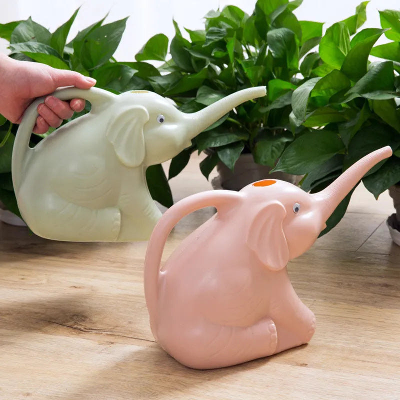 A pink plastic watering can shaped like a sitting baby elephant with a long spout.