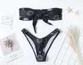 Black printed one-piece swimsuit with a split tube top and backless design.