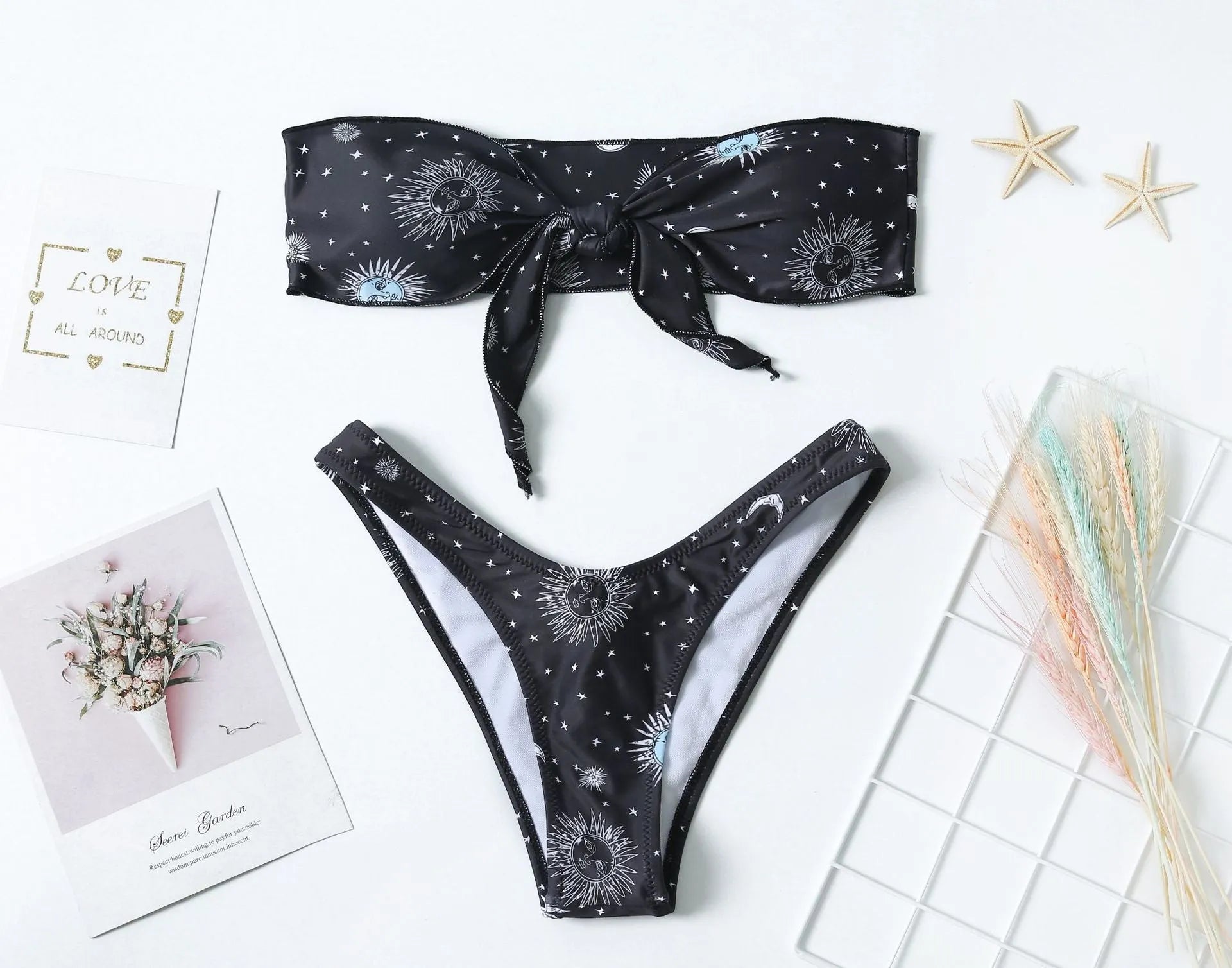 Black printed one-piece swimsuit with a split tube top and backless design.